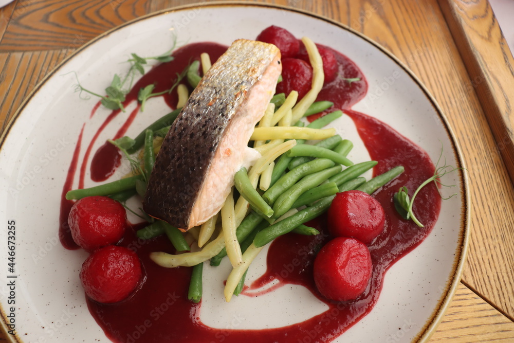 salmon on a vegetable pillow with raspberry sauce and bread balls